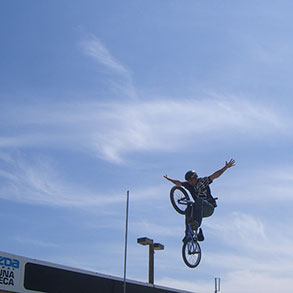 Bike rider in mid-air stretching his arms in a cross