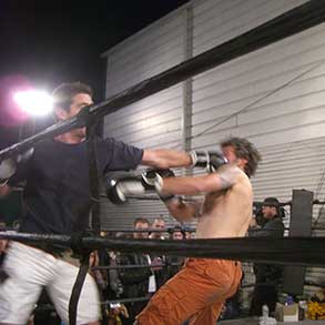 A man lands a punch in the face of another man in a boxing ring