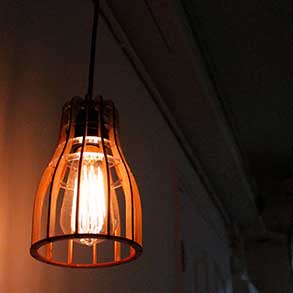 A hanging lightbulb fixture made with lazercut wood